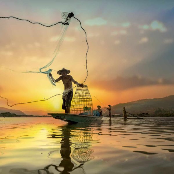 Pêcheur lançant son filet au coucher du soleil, Cambodge