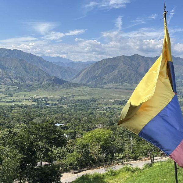 Drapeau colombien flottant au-dessus d'une vallée verdoyante