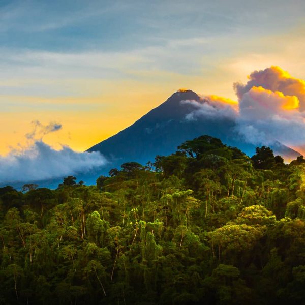 Volcan émergeant au-dessus de la forêt tropicale au coucher du soleil, Costa Rica