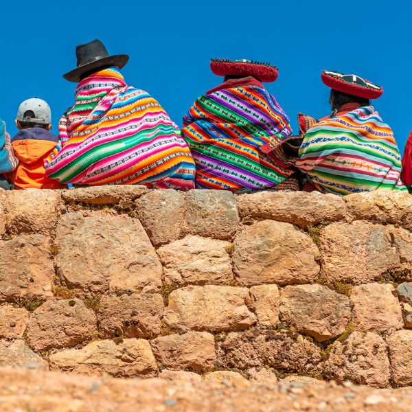 Femmes quechuas en vêtements traditionnels assises sur un mur inca, Pérou