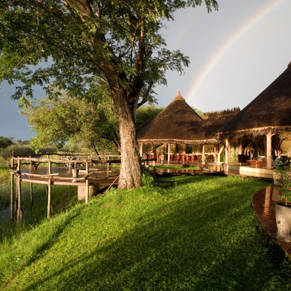 Lodge de safari au toit de chaume sous un arc-en-ciel, Namibie
